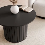 Frontale Ansicht des eleganten Säulentisches Linnea in tiefem Schwarz, der architektonische Strenge und modernes Design im Wohnzimmer vereint.