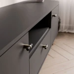 Nahaufnahme der offenen Mittelablage und der geräumigen Schublade des schwarzen TV-Lowboards, ideal für Receiver, Konsolen oder Soundbars.