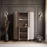 Schräge Ansicht der modernen Hochvitrine Linnea in Beige (Kaschmir), die das abgerundete, fließende Design freigestellt auf weißem Hintergrund präsentiert.