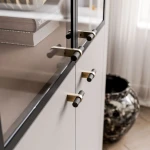 Die Vitrine Linnea in Kaschmir mit geöffneten Türen, welche die großzügigen Regalböden und das praktische Stauraumkonzept zeigt.