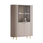 Detailansicht der eleganten, goldfarbenen Metallfüße, die einen luxuriösen und warmen Akzent an der hellen Kaschmir-Vitrine setzen.