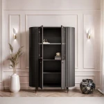 Schräge Ansicht der modernen Hochvitrine Linnea in tiefem Schwarz, die das fließende Design und die eleganten Glas- und Lamellenelemente zeigt.