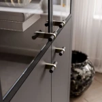 Die schwarze Vitrine Linnea mit geöffneten Türen, welche die großzügigen Regalböden und den durchdachten Stauraum für Geschirr und Dekoration präsentiert.