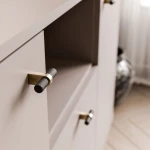 Nahaufnahme der offenen Ablagefläche und der präzisen Spaltmaße der Schubladen des modernen Sideboards Linnea in Kaschmir Beige.