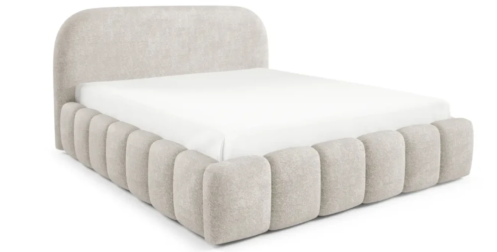Freigestellte Studioansicht des Polsterbettes im beigefarbenen Stoff Monte 3 mit abgerundetem Kopfteil und markantem Rippen-Design am Rahmen.