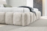 Detaillierte Nahaufnahme der vorderen Ecke des Polsterbettes in der Farbe Monte 3, welche die dicke, weiche Rippenpolsterung im Chunky-Look zeigt.