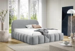 Hell eingerichtetes Schlafzimmer mit dem grauen Polsterbett im gerillten Design aus dem Stoff Monte 84 als stilvoller Mittelpunkt.