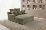 Elegante Wohnlandschaft LAZY ONE im olivgrünen Breitcord Tilia 37, stilvoll arrangiert in einem hellen Raum mit weißen Gardinen.