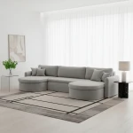 Gemütliches Wohnambiente mit der Couch VERONA U in hellgrauem Bouclé-Stoff Quelle 83 auf einem Teppich.