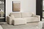 Beigefarbenes Ecksofa KARL XL mit kuscheligem Bouclé-Bezug Quelle 06 in einem eleganten Raum neben dunklen Vorhängen.
