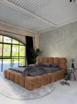 inladendes Schlafzimmer-Ambiente mit dem Zimt Polsterbett 140x200 Cloudi im samtigen Bezug Lumo (Chenille), stilvoll dekoriert mit grauer Bettwäsche und Kuscheldecke.