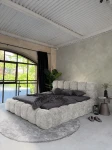 inladendes Schlafzimmer-Ambiente mit dem Hellgrau Polsterbett 140x200 Cloudi im samtigen Bezug Lumo (Chenille), stilvoll dekoriert mit grauer Bettwäsche und Kuscheldecke.