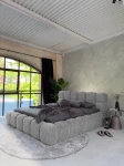 inladendes Schlafzimmer-Ambiente mit dem Grau  Polsterbett 180x200 Cloudi im samtigen Bezug Lumo (Chenille), stilvoll dekoriert mit grauer Bettwäsche und Kuscheldecke.