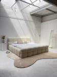 Schräge Ansicht des französischen Polsterbetts DIEGO (160x200 cm) in Coral Bouclé, stilvoll arrangiert und harmonisch integriert in eine moderne Schlafzimmerumgebung.