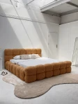 Schräge Ansicht des französischen Polsterbetts DIEGO (160x200 cm) in Coral 35 Bouclé, stilvoll arrangiert und harmonisch integriert in eine moderne Schlafzimmerumgebung.