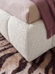 Detaillierte Nahaufnahme der voluminösen Polsterung des Bettes Dakota slim (180x200 cm), die die weiche Textur des Bouclé-Stoffs Quelle zeigt.