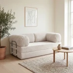 Gemütliches Schlafsofa MUNO aus Poso Cord Stoff mit den Maßen 200x100 cm, stilvoll arrangiert in einem hellen Wohnzimmer.
