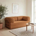 Gemütliches Schlafsofa MUNO aus Poso Cord Stoff mit den Maßen 200x100 cm, stilvoll arrangiert in einem hellen Wohnzimmer.