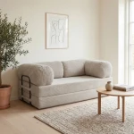 Gemütliches Schlafsofa MUNO aus Poso Cord Stoff mit den Maßen 200x100 cm, stilvoll arrangiert in einem hellen Wohnzimmer.