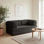 Gemütliches Schlafsofa MUNO aus Poso Cord Stoff mit den Maßen 200x100 cm, stilvoll arrangiert in einem hellen Wohnzimmer.