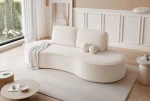 Ein gemütliches Wohnzimmer mit einem organisch geformten Design-Sofa, bezogen mit hochwertigem Riviera Velour Stoff.