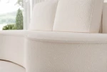 Nahaufnahme der Rückenlehne und Sitzfläche, die die feine, luxuriöse Textur der Sofa-Bezüge aus Abriamo Boucle und Riviera Velour zeigt.