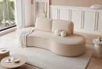 Das einzigartige, asymmetrische Sofa im Abriamo Boucle Design setzt einen modernen, gemütlichen Akzent in einem lichtdurchfluteten Raum.