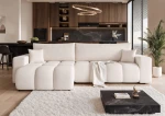 Frontalansicht des Design Ecksofas OFI XL (278x145 cm) mit weichem Bouclé-Bezug, stilvoll arrangiert in einem modernen Wohnzimmer.