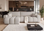 Frontalansicht des Design Ecksofas OFI XL (278x145 cm) mit weichem Bouclé-Bezug, stilvoll arrangiert in einem modernen Wohnzimmer.
