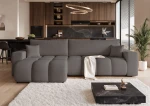 Frontalansicht des Design Ecksofas OFI XL (278x145 cm) mit weichem Bouclé-Bezug, stilvoll arrangiert in einem modernen Wohnzimmer.