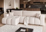 Frontalansicht des Design Ecksofas OFI XL (278x145 cm) mit weichem Bouclé-Bezug, stilvoll arrangiert in einem modernen Wohnzimmer.