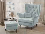 Frontalansicht des Design Ohrensessels SCANDI mit passendem Hocker, bezogen mit edlem Samt Trinity, stilvoll arrangiert in einem modernen Wohnzimmer.