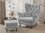 Frontalansicht des Design Ohrensessels SCANDI mit passendem Hocker, bezogen mit edlem Samt Trinity, stilvoll arrangiert in einem modernen Wohnzimmer.