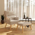 Das komfortable Set aus Sessel LILA und passendem Hocker im weichen Bouclé-Stoff, ideal positioniert für entspannte Momente im Wohnbereich.