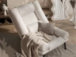 Frontalansicht des Sessels LILA inklusive Hocker mit weichem Bouclé-Bezug, stilvoll arrangiert in einem modernen Wohnzimmer.