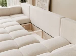 Das ausgeklappte Schlafsofa der Wohnlandschaft BUENO U (318x145 cm) aus Bouclé-Stoff mit geöffnetem, integriertem Bettkasten für zusätzlichen Stauraum.