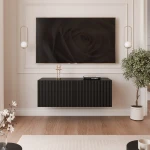 Frontalansicht des hängenden TV-Lowboards ANGEL (100 cm) mit stilvollen geriffelten Fronten und stimmungsvoller LED-Beleuchtung, arrangiert in einem modernen Wohnzimmer.