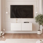 Frontalansicht des hängenden TV-Lowboards ANGEL (100 cm) mit stilvollen geriffelten Fronten und stimmungsvoller LED-Beleuchtung, arrangiert in einem modernen Wohnzimmer.