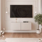 Frontalansicht des hängenden TV-Lowboards ANGEL (100 cm) mit stilvollen geriffelten Fronten und stimmungsvoller LED-Beleuchtung, arrangiert in einem modernen Wohnzimmer.