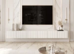 Frontalansicht des hängenden TV-Lowboards ANGEL (300 cm) mit stilvollen geriffelten Fronten und stimmungsvoller LED-Beleuchtung, arrangiert in einem modernen Wohnzimmer.
