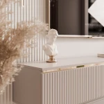 Nahaufnahme des TV-Lowboards SELIA, welche das elegante Design der drei geriffelten Rillenfronten in Kaschmir und die edlen Goldakzente im Detail präsentiert.