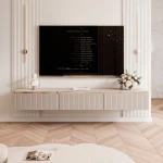 Frontalansicht des hängenden TV-Lowboards SELIA (200 cm) in Kaschmir mit geriffelten Rillenfronten und Goldakzenten, stilvoll arrangiert in einem modernen Wohnzimmer.