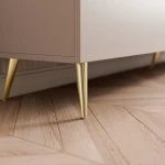 Detailansicht der stilvollen goldenen Füße des TV-Lowboards SELIA 200 cm, welche die stabile Konstruktion und das glamouröse Design des stehenden Möbels unterstreichen.