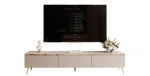 Frontale Ansicht des 200 cm breiten TV-Lowboards SELIA in edlem Kaschmir, die das minimalistische Design und die markanten goldenen Füße zeigt, freigestellt auf weißem Hintergrund.