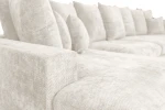 Nahaufnahme der Polsterung der Wohnlandschaft SELLO U-Form, welche die feine und kuschelige Textur des hochwertigen Flow (Chenille) Stoffes im Detail präsentiert.