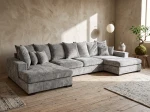 Frontalansicht der großen Wohnlandschaft SELLO in U-Form mit weichem Bezug aus Flow (Chenille), stilvoll arrangiert in einem geräumigen Wohnzimmer.