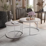 Frontalansicht des modernen Couchtisch-Sets LAVO 2in1 mit elegantem weißem Gestell, stilvoll arrangiert in einem gemütlichen Wohnzimmer.