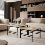 Frontalansicht des modernen Couchtisch-Sets FORMA 2in1 mit markantem schwarzem Gestell, stilvoll arrangiert in einem gemütlichen Wohnzimmer.