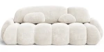Frontalansicht des modernen Sofas STONE im Stoff Vibe 03, stilvoll arrangiert in einem gemütlichen Wohnzimmer