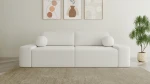 Frontalansicht des modernen Sofas OVAL im edlen Stoff Anthology 1, stilvoll arrangiert in einem gemütlichen Wohnzimmer.
